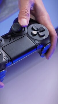 Hands use joystick in video game, pressing control buttons. Vertical video