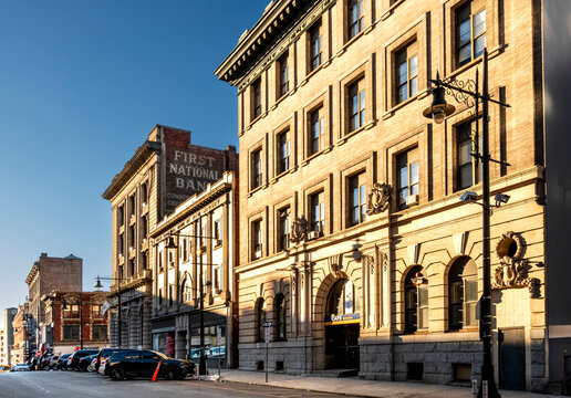 Paterson, NJ - US - Mar 1, 2026 Warm late-day light illuminates historic brick buildings along Ellison Street in downtown Paterson, New Jersey, including the faded First National Bank sign.