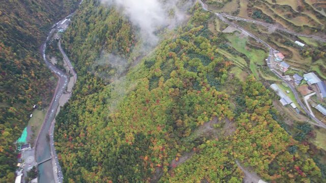 Drone view of Yangrong Hade, or Yangrong Village, well-preserved Jiarong Tibetan village in Aba, Sichuan, China. Colorful autumn forest in rainy day. 4k real time footage b roll shot travel concept