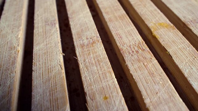 Close Up of Parallel Wooden Slats With Visible Grain and Knife Marks Creating Linear Pattern and Rustic Kitchen Texture Background