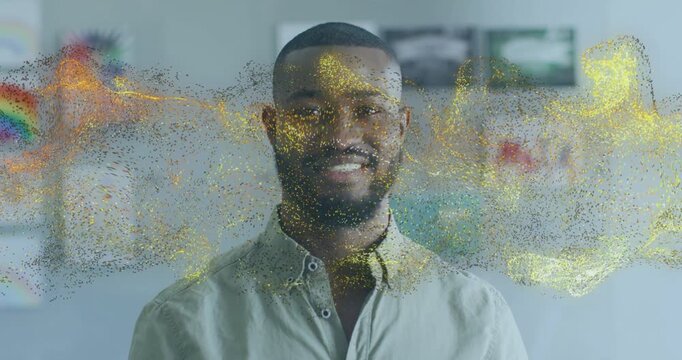 Man smiling and activating particle cloud across face with warm light and blurred art showing tech