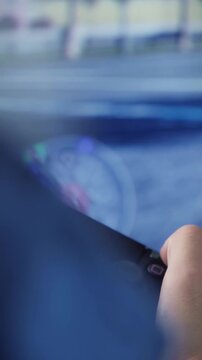 Close up of hands playing video games on console in front of TV. Vertical video