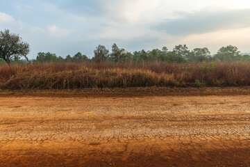 Obraz premium Landscape of gravel road in countryside at sunset. Side view of dirt road on top mountain. road background.