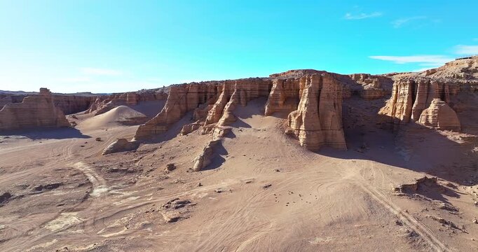 Panoramic view of yardang landforms and weathered rock formations in the Gobi Desert, Xinjiang, China. Vast arid desert under a clear blue sky.