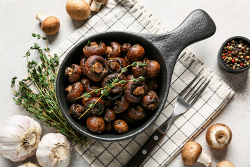 Frying pan with tasty fried mushrooms, thyme and garlic on white background