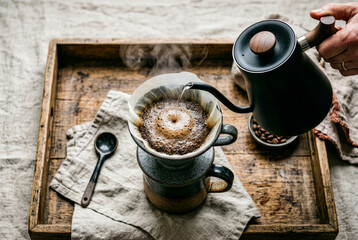 Fototapeta premium Warm editorial lifestyle series of specialty coffee rituals at home. Ceramic mugs, pour over, coffee beans, wooden surfaces. Soft natural light, film grain, cozy morning atmosphere.
