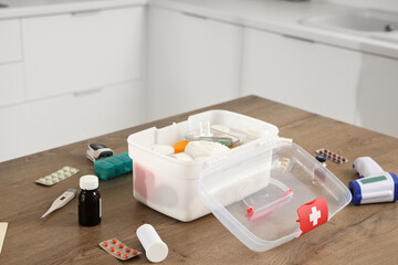 First aid kit with medications on table in kitchen