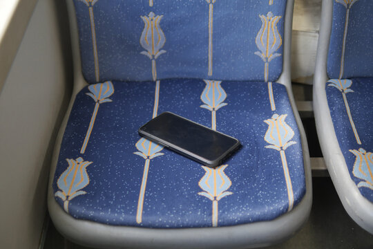 Phone left on a seat in public transport space. lost smart phone concept 