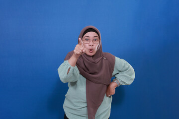 Naklejka premium An Asian Muslim woman looks frustrated because something is upsetting her. Pointing displeased and frustrated.