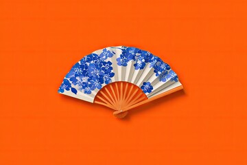 Ornate paper fan, blue floral design, orange background