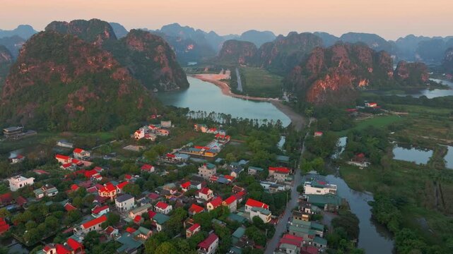 Aerial view of Trang An, Ninh Binh, Vietnam, showcasing the city's unique landscape with limestone karsts and traditional architecture, attracting tourists to explore its beauty.