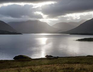 Fototapeta premium Mystic landscape lake scenery in Scotland: Cloudy sky, sunbeams, and mountain range in Loch Linnhe__storm clouds over the sea.