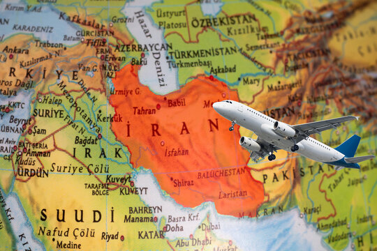 A passenger plane is flying over a map of Iran painted red. Flights cancelled due to the Iran war. Political crisis have affected air transportation. Aviation idea concept. Top view, above, up. No peo
