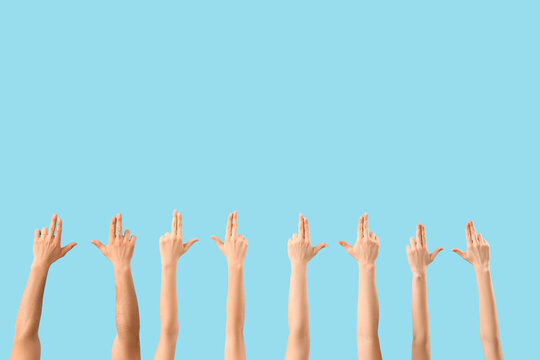 Many hands showing gun gesture on blue background