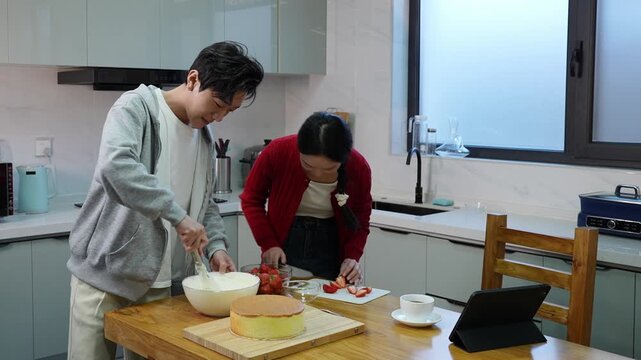 Young couple having fun baking a cake