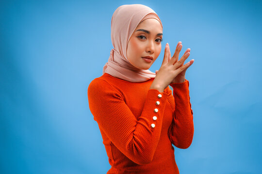 Chic young Asian Muslim woman wearing veil hijab with make up posing and looking to the camera.
