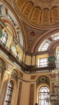 Ornate interior of Dolmabahce Mosque in Istanbul, Turkey. Features a grand dome, arched windows, and Ottoman Baroque architecture. Historic Bezmialem Valide Sultan Mosque by Bosphorus.