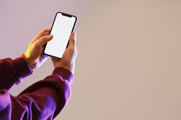 Naklejka premium Man holding blank mobile phone on grey background