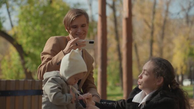 Father photographs joyful family outing. Dad records spontaneous and loving family experience at park. Precious family interaction captured by father during outdoor visit with relatives