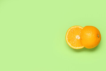 Fototapeta premium Composition with ripe tasty cut in half orange on green background