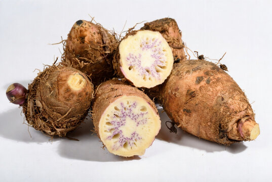 Fresh oca tubers with cut pieces showing purple star patterns inside