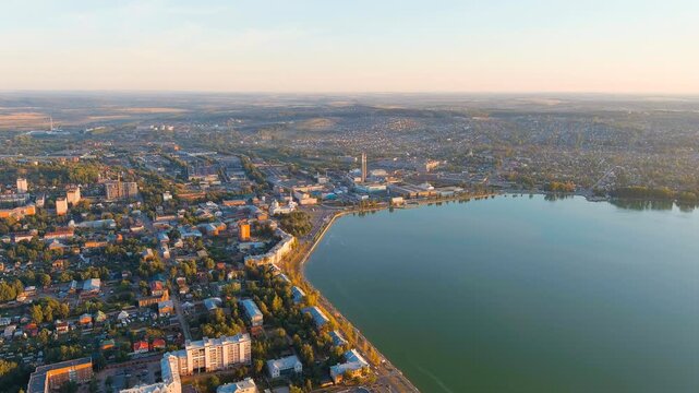 Russia, Votkinsk. Embankment with a dam and factories. Votkinsk is a city in the Udmurt Republic. Sunset time. Drone footage