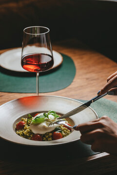 Fine dining Italian pasta with creamy burrata served with glass of red wine. Romantic restaurant atmosphere concept for luxury dining, hospitality and food marketing visuals.