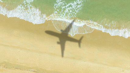 Fototapeta premium Aerial view of shadow passenger plane silhouette and sandy beach blue sea with waves at sea beach summer vacation sea travel concept 