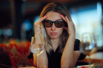 Woman Wearing Sunglasses Looking Sad and Stressed in Restaurant. Person hiding behind dark shades...