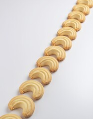 Golden Baked Crescent Cookies Aligned in a Diagonal Pattern on a Clean White Background
