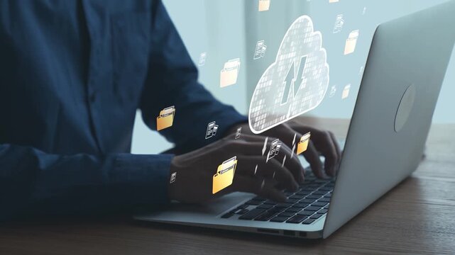 Person typing on laptop with cloud storage symbol and digital file icons representing data management and online collaboration in modern office environment. Qubit.