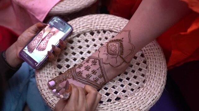 Mehendi design applying on the legs of an Indian bride