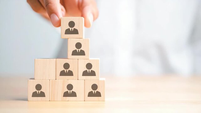 Person stacking wooden blocks with people icons forming a pyramid