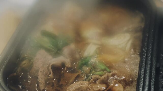 Shabu Shabu or Sukiyaki or hot pot ,Hand holding pork using chopsticks, Japanese food in restaurant