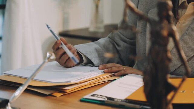 Justice and law concept. Gavel on sounding block in hand's Male judge at a courtroom, working with document law books, report the case on table in modern office.