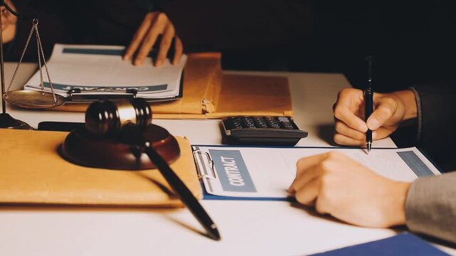 Justice and law concept. Gavel on sounding block in hand's Male judge at a courtroom, working with document law books, report the case on table in modern office.