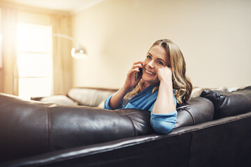 Mobile, call and woman relax in home for news, listen or gossip on weekend break in living room. Phone, happy person and talking to contact on sofa in house for communication, story and connection