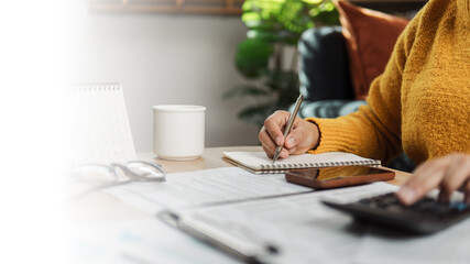 Businessman calculates taxes using calculator and laptop. The concept of tax return preparation and...