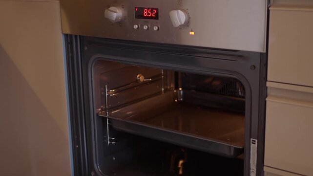 Person placing ramekins of creme brulee into oven for baking