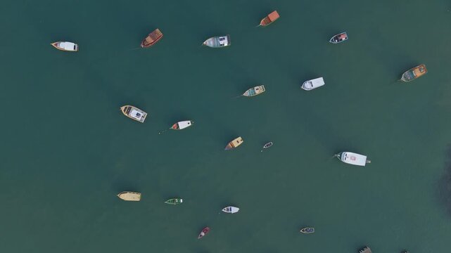 High-angle aerial of traditional colorful fishing boats anchored at Arma&ccedil;&atilde;o Beach. Authentic coastal village in Santa Catarina, Brazil.