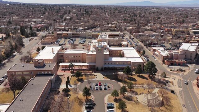 A cinematic push-in toward the iconic state capitol building in downtown Santa Fe. This 4K shot captures a central landmark of the New Mexico state capital.