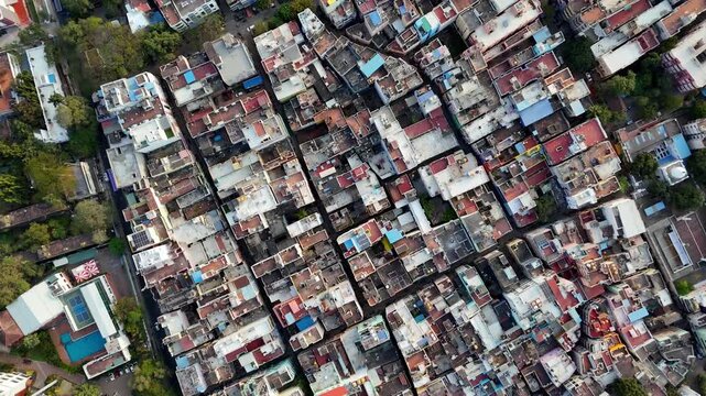 Drone view straight above a compact cityscape, showcasing clustered houses, varied roof patterns, and closely spaced lanes. Aerial view of M. A. Chidambaram Stadium (Chepauk)