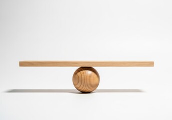 Wooden plank rests perfectly balanced atop a spherical fulcrum against a bright background.