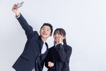 スマホで自撮りをする男女の学生