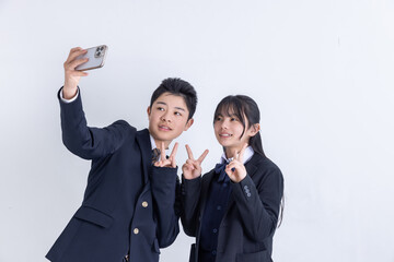 スマホで自撮りをする男女の学生