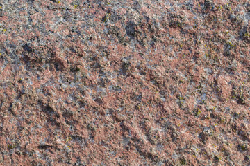 Tekstura różowego granitu, chropowata ziarnista powierzchnia kamienia z czarnymi i białymi drobinkami, naturalne tło mineralne. © Henryk Guziak