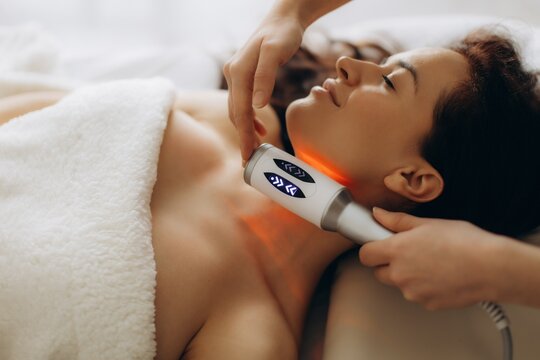 Woman receiving red light therapy on neck. endosphere facial therapy
