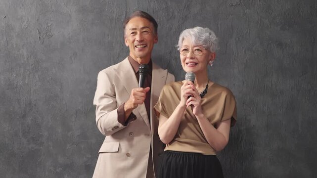 マイクを持って歌を歌うシニア男女　ライフスタイルイメージ