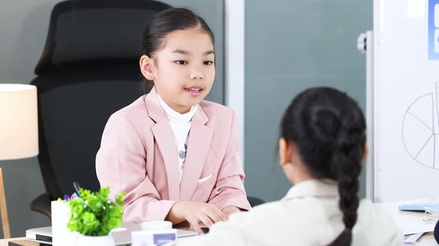 Young Asian Girl in Pink Blazer Leading a Corporate Business Meeting
