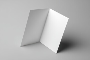 Fototapeta premium Vertical bi-fold brochure card on gray studio surface with soft lighting and clean layout